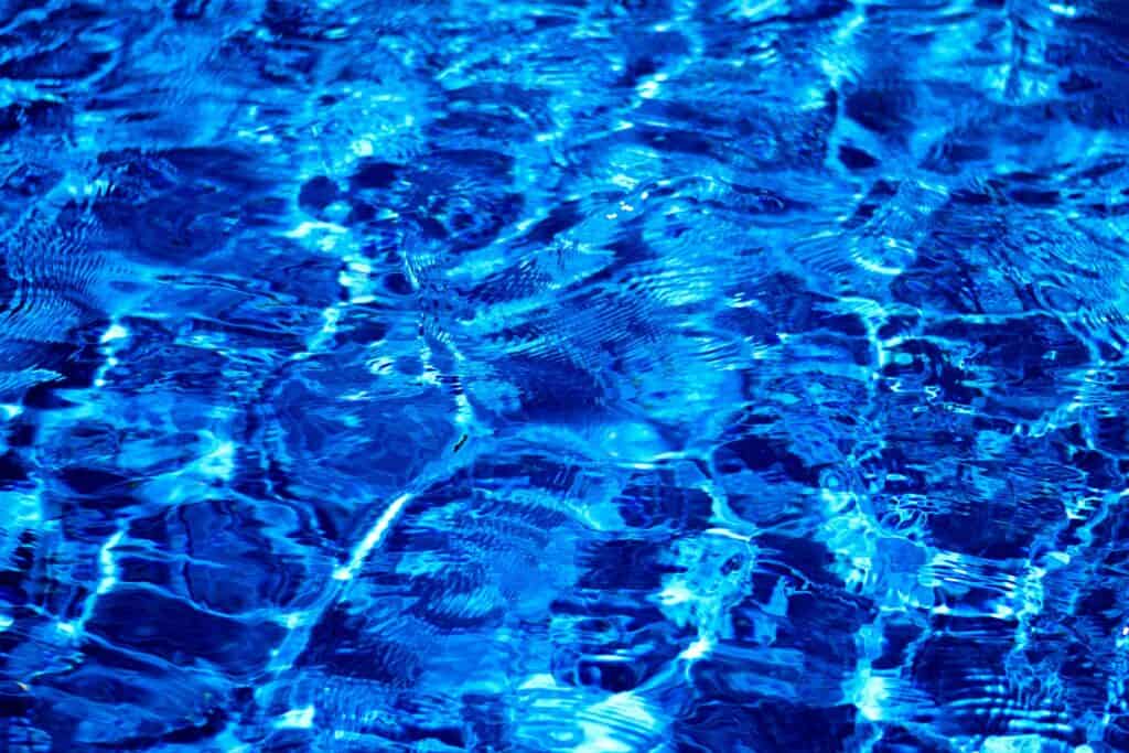 Dynamic and vibrant ripples on a blue water surface, showcasing light and texture.